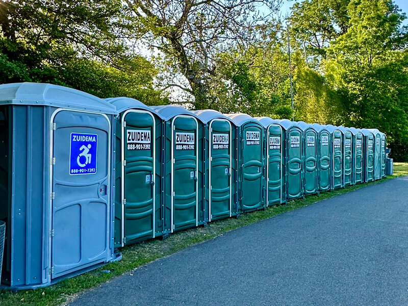 row of Zuidema portable toilets by woods