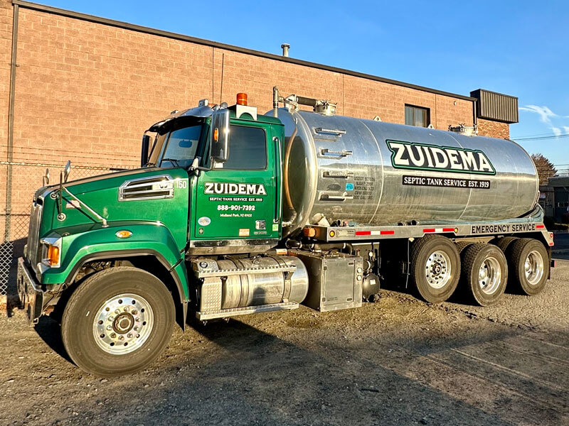 green and silver Zuidema septic truck